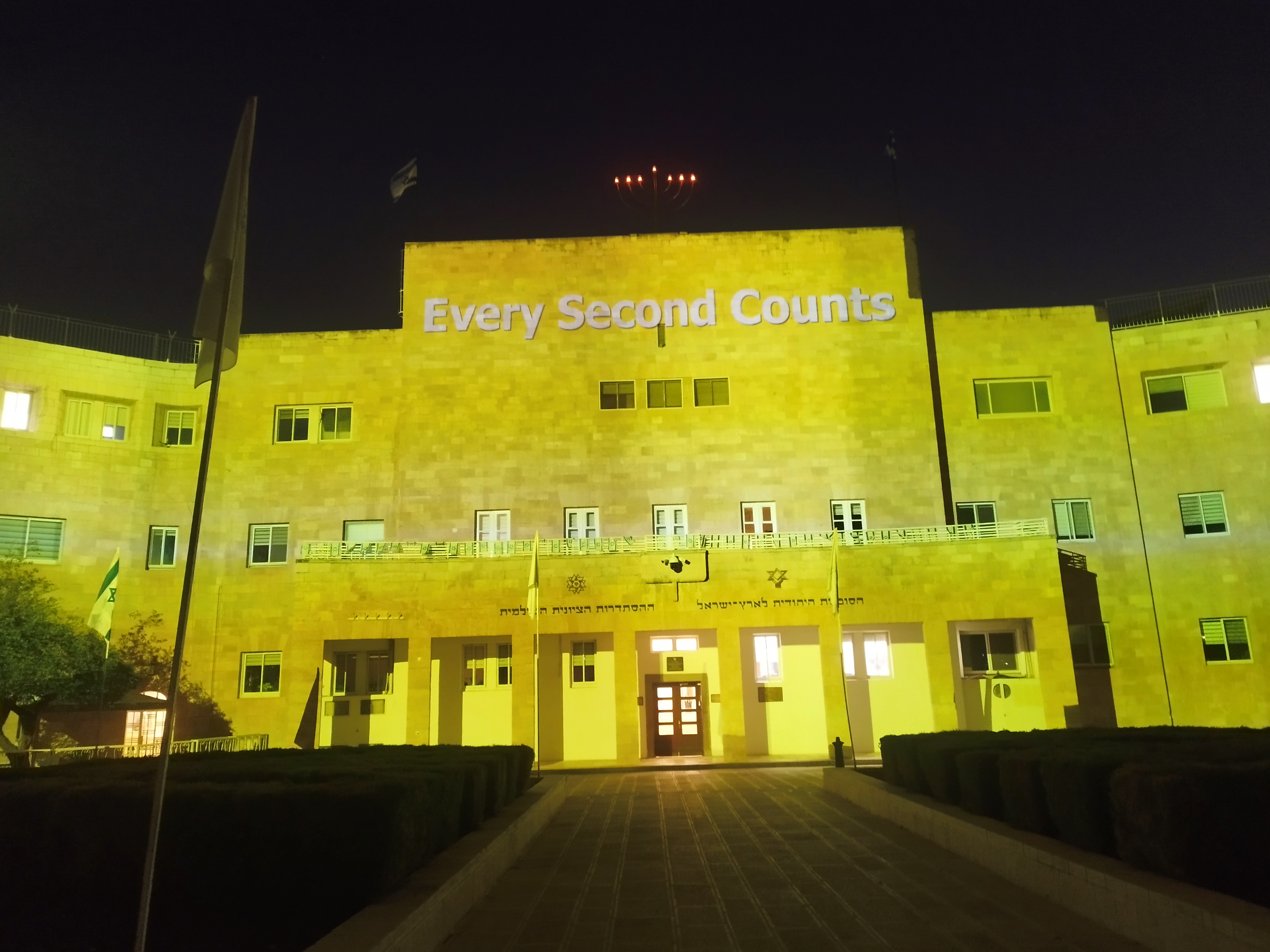 The National Institutions building is lit up in yellow